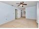 This light blue bedroom features neutral carpet, breezy white curtains, and an attached bathroom at 8720 Sw 108Th Ln, Ocala, FL 34481