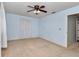 This light blue bedroom features neutral carpet, breezy white curtains, and ceiling fan at 8720 Sw 108Th Ln, Ocala, FL 34481