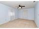 This light blue bedroom features neutral carpet, breezy white curtains, and ceiling fan at 8720 Sw 108Th Ln, Ocala, FL 34481