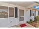 Close-up of the entrance with a screen door, black shutters, and white siding at 8720 Sw 108Th Ln, Ocala, FL 34481