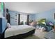 Spacious bedroom featuring light blue walls, window, comfortable bed, and desk area for gaming at 1305 Rebecca Dr, Haines City, FL 33844