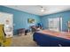 Bedroom featuring a blue wall, neutral carpet, and a window with natural light at 1305 Rebecca Dr, Haines City, FL 33844