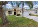 Charming two-story home with mature landscaping, a palm tree, two car garage and neutral color palette at 1305 Rebecca Dr, Haines City, FL 33844