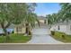 Charming two-story home with mature landscaping, palm tree, and a two car garage at 1305 Rebecca Dr, Haines City, FL 33844