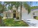 Charming two-story home with mature landscaping, a palm tree and an attached two car garage at 1305 Rebecca Dr, Haines City, FL 33844