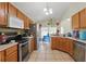 Well-lit kitchen featuring stainless steel appliances, tile flooring, and wooden cabinets at 1305 Rebecca Dr, Haines City, FL 33844