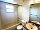 A full bathroom with a shower-tub combo, and a tile surround at 1355 Dexter E Dr, Port Orange, FL 32129