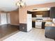 Kitchen and dining area featuring wood cabinets, white appliances, and white tile flooring at 1355 Dexter E Dr, Port Orange, FL 32129