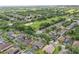 Expansive aerial view of a suburban neighborhood adjacent to a lush golf course, showcasing a serene and active lifestyle at 1956 Southern Dunes Blvd, Haines City, FL 33844