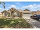 Inviting one-story home with a well-manicured lawn, arched windows, and an attached two-car garage at 1956 Southern Dunes Blvd, Haines City, FL 33844