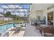 Enjoy the view of the pool from the screened-in patio with table and chairs for outdoor dining at 1956 Southern Dunes Blvd, Haines City, FL 33844