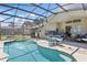 Relax and enjoy this beautiful pool area, complete with outdoor seating and dining, inside a screened enclosure at 1956 Southern Dunes Blvd, Haines City, FL 33844