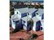 An aerial view of a three-story colorful home with multiple balconies and ample parking at 3000 Ocean Shore Blvd # 150, Ormond Beach, FL 32176