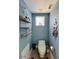 Compact half bathroom featuring blue walls, shelving, and a cute nautical theme at 3000 Ocean Shore Blvd # 150, Ormond Beach, FL 32176