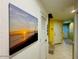 Hallway with beach-themed artwork and white doors leading to bedrooms and bathrooms at 3000 Ocean Shore Blvd # 150, Ormond Beach, FL 32176