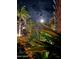 Lush tropical plants and bushes in the foreground with homes illuminated by the moon at 3000 Ocean Shore Blvd # 150, Ormond Beach, FL 32176