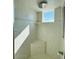Bright, tiled walk-in shower with a rain shower head, corner seat, and a window providing natural light at 3000 Ocean Shore Blvd # 150, Ormond Beach, FL 32176