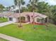 Charming single-story brick home featuring a lush lawn and beautiful palm trees in a tranquil setting at 4622 Secret River Trl, Port Orange, FL 32129