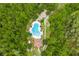 Aerial view of a community pool and clubhouse surrounded by lush green trees in a peaceful, natural setting at 5 Cantilever Ct, Ormond Beach, FL 32174