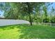 Large, well-maintained backyard featuring lush green grass, mature trees, and a white privacy fence at 5 Cantilever Ct, Ormond Beach, FL 32174