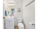 Well-lit half-bathroom with white vanity, oval mirror, and beach-themed decorations at 5 Cantilever Ct, Ormond Beach, FL 32174