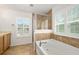 Bright bathroom featuring a soaking tub, glass-enclosed shower, and shuttered windows at 5 Cantilever Ct, Ormond Beach, FL 32174