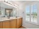 Bathroom featuring a double vanity, shuttered windows, and a view of the glass-enclosed shower at 5 Cantilever Ct, Ormond Beach, FL 32174