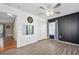 Bright bedroom featuring gray wood flooring, a ceiling fan, and natural light from a window at 5 Cantilever Ct, Ormond Beach, FL 32174
