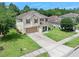 Inviting two-story home featuring a well-kept lawn, driveway and beautiful trees in the background at 5 Cantilever Ct, Ormond Beach, FL 32174