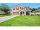 Charming two-story home featuring a well-manicured lawn, neutral stucco, and inviting front porch at 5 Cantilever Ct, Ormond Beach, FL 32174
