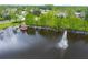 Scenic view of a pond with a fountain, wooden dock and surrounding trees with neighborhood in the background at 5 Cantilever Ct, Ormond Beach, FL 32174