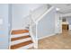 Wooden staircase with white banister and tile flooring at the base, leading to the upper level at 5 Cantilever Ct, Ormond Beach, FL 32174