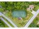 Aerial view of a tennis court surrounded by roads, trees, a playground and a gazebo at 5 Cantilever Ct, Ormond Beach, FL 32174