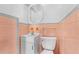 Bathroom featuring pink tiles, a vanity sink, mirror, and toilet at 1159 Magnolia Ave, Daytona Beach, FL 32114