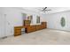 This bedroom features a ceiling fan, carpeted floor, and built-in cabinets by the window and front door at 1159 Magnolia Ave, Daytona Beach, FL 32114