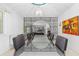 Stylish dining area with a modern glass table, comfortable seating, and unique artwork, well lit by a chandelier at 1159 Magnolia Ave, Daytona Beach, FL 32114