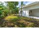 Side view of the house with a grassy yard and mature trees, some palm trees, offering a serene outdoor space at 1159 Magnolia Ave, Daytona Beach, FL 32114