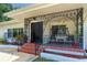 Charming front porch featuring unique ironwork, a swing and tile steps leading to the front door at 1159 Magnolia Ave, Daytona Beach, FL 32114