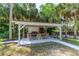 Covered gazebo with grill and picnic table for outdoor entertaining, surrounded by lush greenery at 1159 Magnolia Ave, Daytona Beach, FL 32114