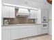 Bright kitchen with white cabinetry, double oven, cooktop, and ample countertop space at 1159 Magnolia Ave, Daytona Beach, FL 32114
