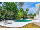 Refreshing backyard pool, complete with lounge seating and tropical foliage at 1159 Magnolia Ave, Daytona Beach, FL 32114