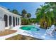 Back exterior showcasing a private pool with a spacious lounge and verdant landscaping at 1159 Magnolia Ave, Daytona Beach, FL 32114