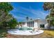 Back exterior featuring a private pool, patio area, and lush tropical landscaping at 1159 Magnolia Ave, Daytona Beach, FL 32114