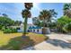 Back exterior showcasing white stucco walls, blue tile roofing, and covered carport at 1159 Magnolia Ave, Daytona Beach, FL 32114
