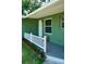 Welcoming entryway with white railing, green exterior, and freshly landscaped garden at 1301 Oakwood Ave, Daytona Beach, FL 32114