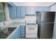 View of kitchen with blue cabinets, stainless steel appliances, and new gray countertops at 1301 Oakwood Ave, Daytona Beach, FL 32114