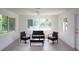 Bright living room featuring gray floors and wicker furniture providing views of the lush outdoors at 1301 Oakwood Ave, Daytona Beach, FL 32114