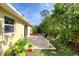 Backyard patio with sliding glass door and table set, with lush green landscaping at 1465 Admrial Nimitz Ave, Daytona Beach, FL 32124