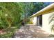 Outdoor patio area with table set and sliding glass door, nestled in a shaded backyard at 1465 Admrial Nimitz Ave, Daytona Beach, FL 32124