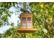 Hanging wooden bird feeder or lantern with decorative panes in a lush green tree at 1465 Admrial Nimitz Ave, Daytona Beach, FL 32124
